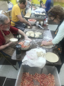A crew of volunteers making pasties in the kitchen.