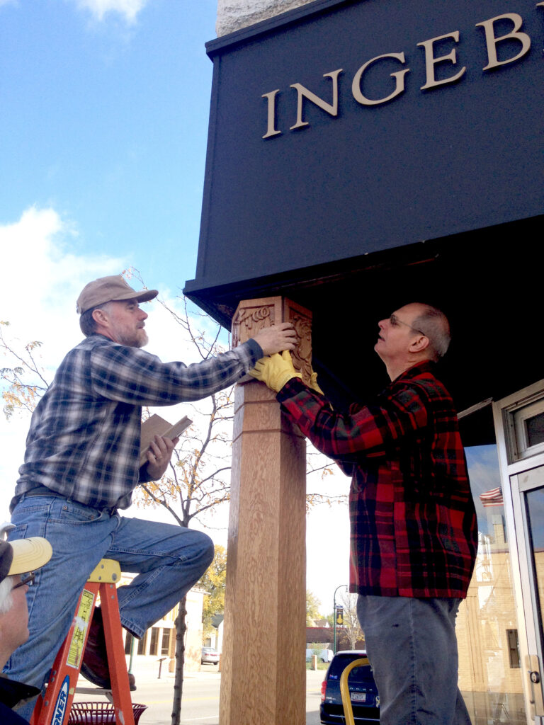 Jock Holmen on a ladder, installing the post cover.