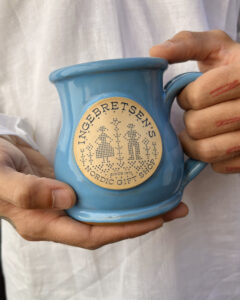 Hands holding the ingebretsen's deneen mug